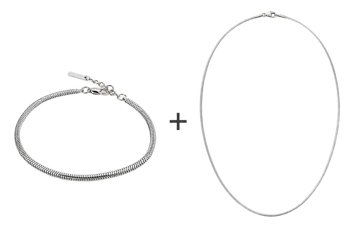 Zilverkleurige VIBE-armband en ketting met een plusteken ertussen op een witte achtergrond